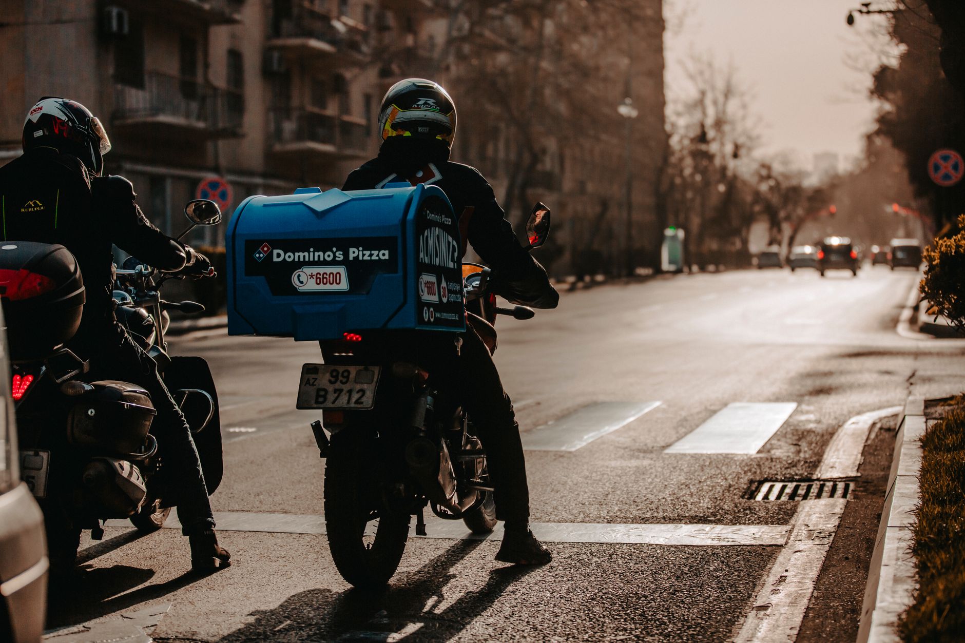 A delivery rider carrying food boxes through the city